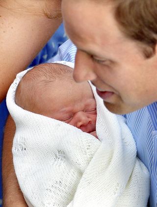 Prince William holding his baby son
