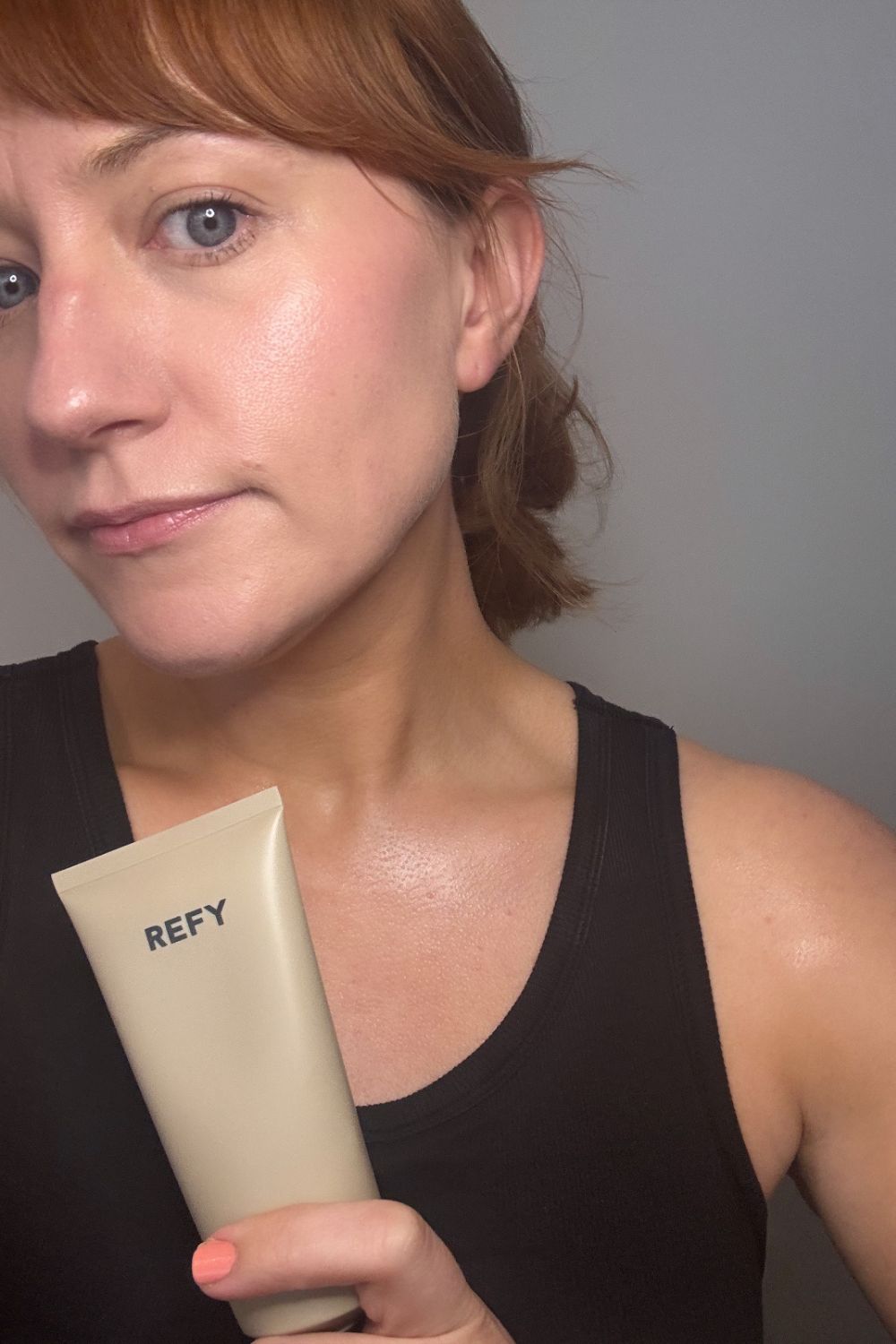 matilda holding a tube of refy body glow