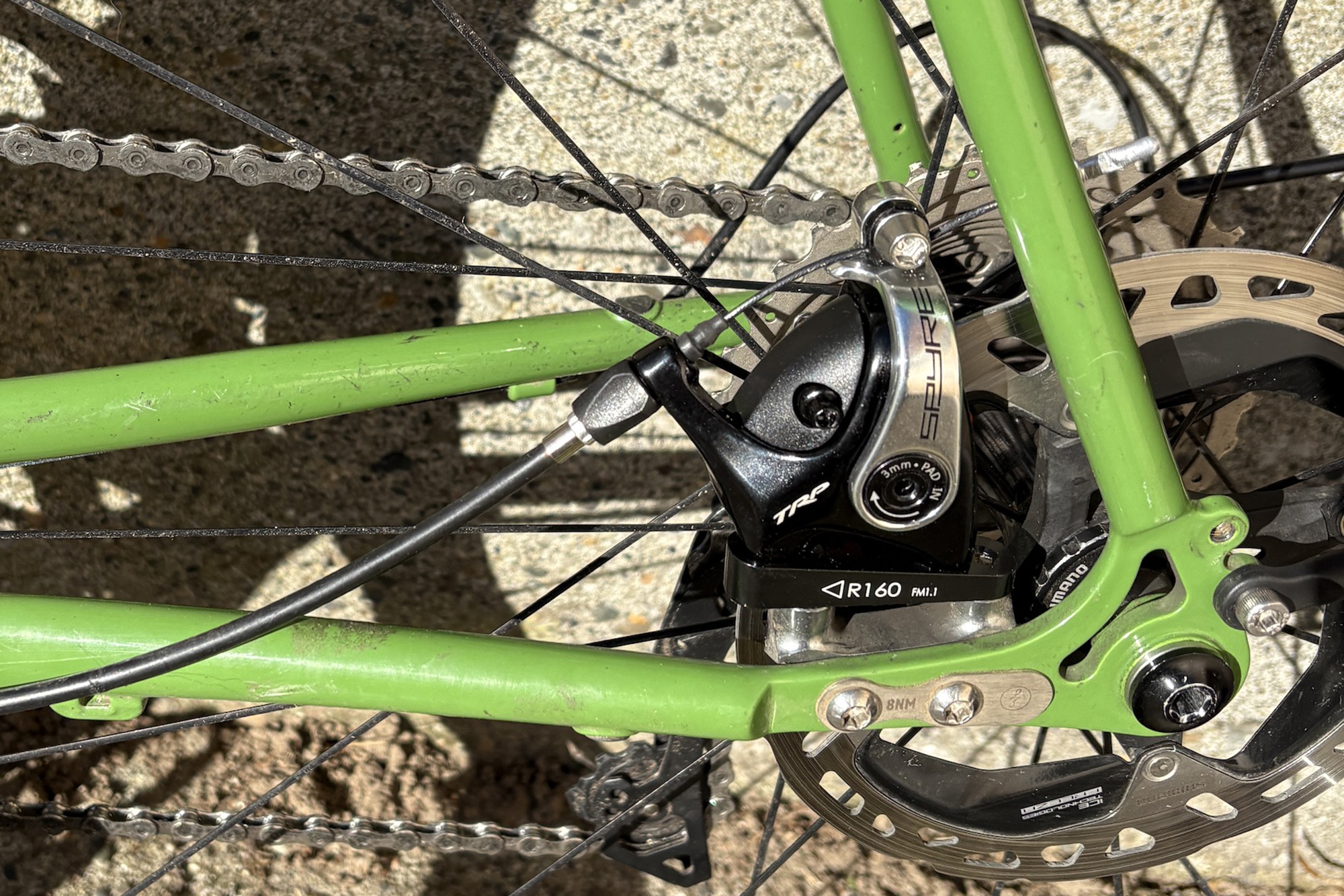 TRP Spyre Mechanical disc brakes using Shimano Rotors fitted to the chainstay of a green bike.