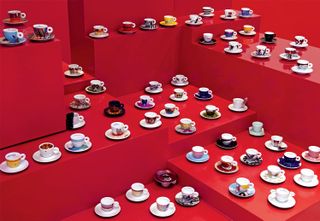 Collection of teacups & saucers on red display