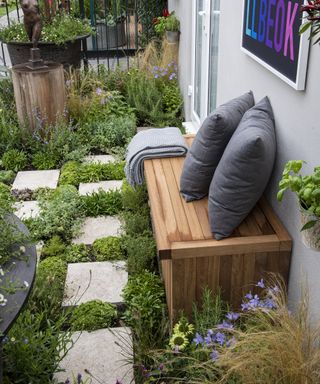 A small balcony garden with paving slabs interspersed with ground cover