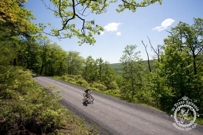 Barry Croker descends a gravel road in sight of a valley backdrop