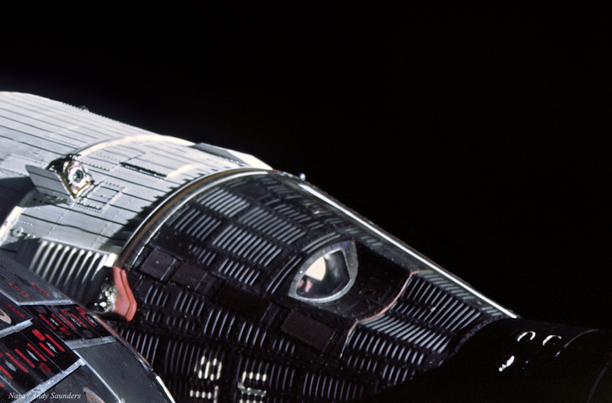 an astronaut peers out of a spacecraft in orbit