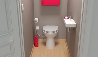 A macerator toilet in a bathroom with grey wall