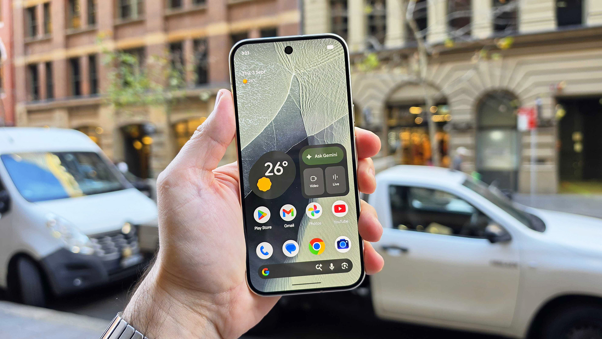 In-hand image of Google Pixel 11 Pro in the street during day time