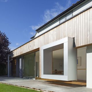 house exterior with glass window and lawn