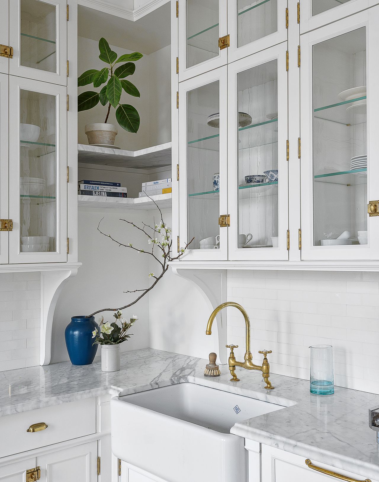 White kitchen with glass fronted cabinets and granite countertops