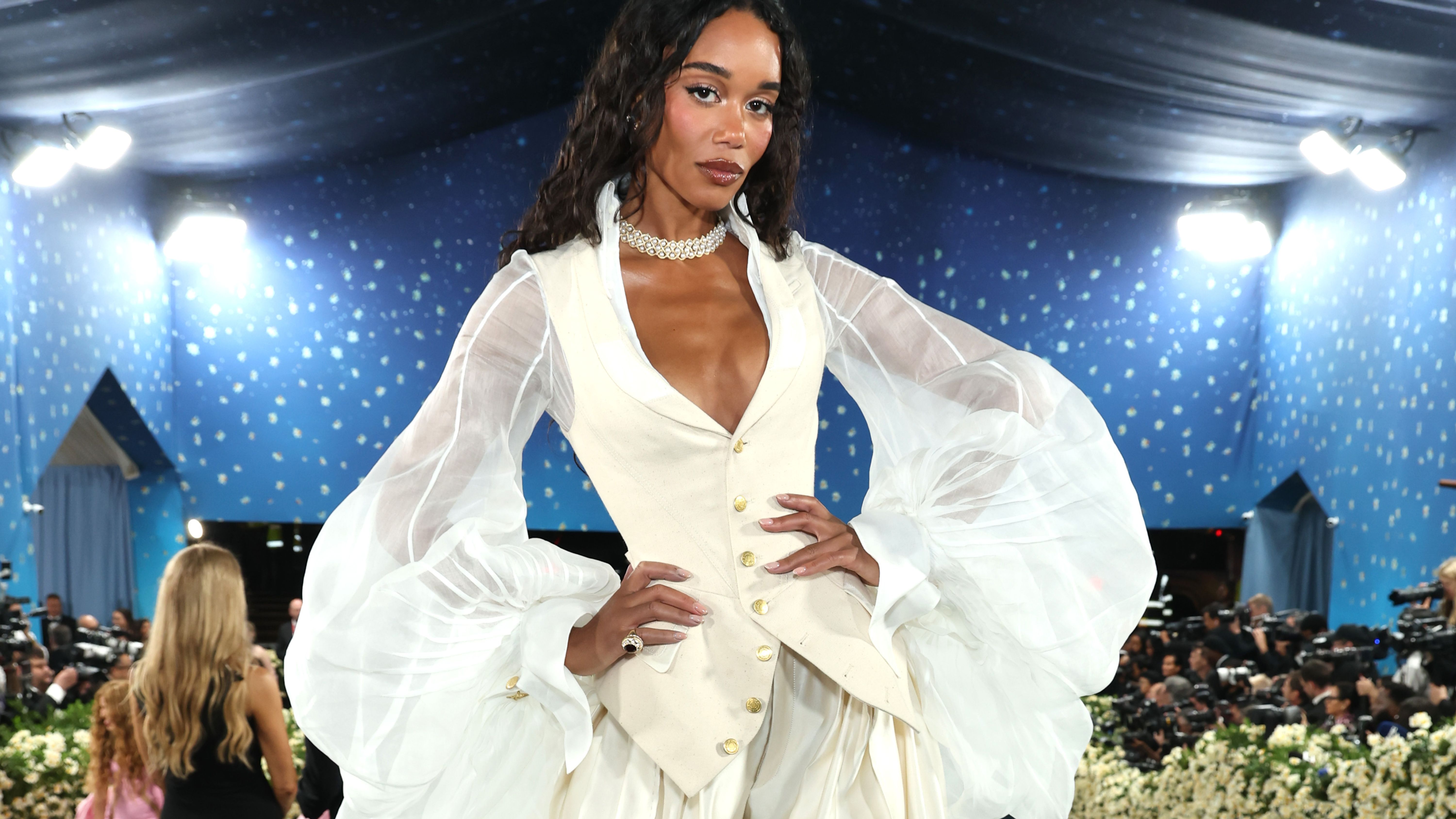 Laura Harrier wears a pair of cream satin trousers at the Met Gala 2025