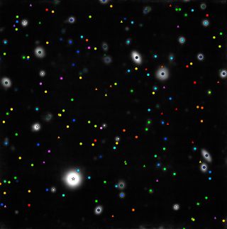 In this annotated image, triangles represent objects newly discovered by MUSE. White stars represent faint Milky Way stars, and circles are objects seen by the Hubble Space Telescope. Blue objects are relatively nearby, with green and yellow ones more distant. Pink and purple objects represent galaxies seen when the universe was less than 1 billion years old, according to ESO.