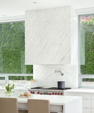 Modern white kitchen ideas with a large white marble hood over cooker