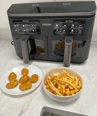 COSORI dual basket air fryer with cooked French fries and plant-based nuggets