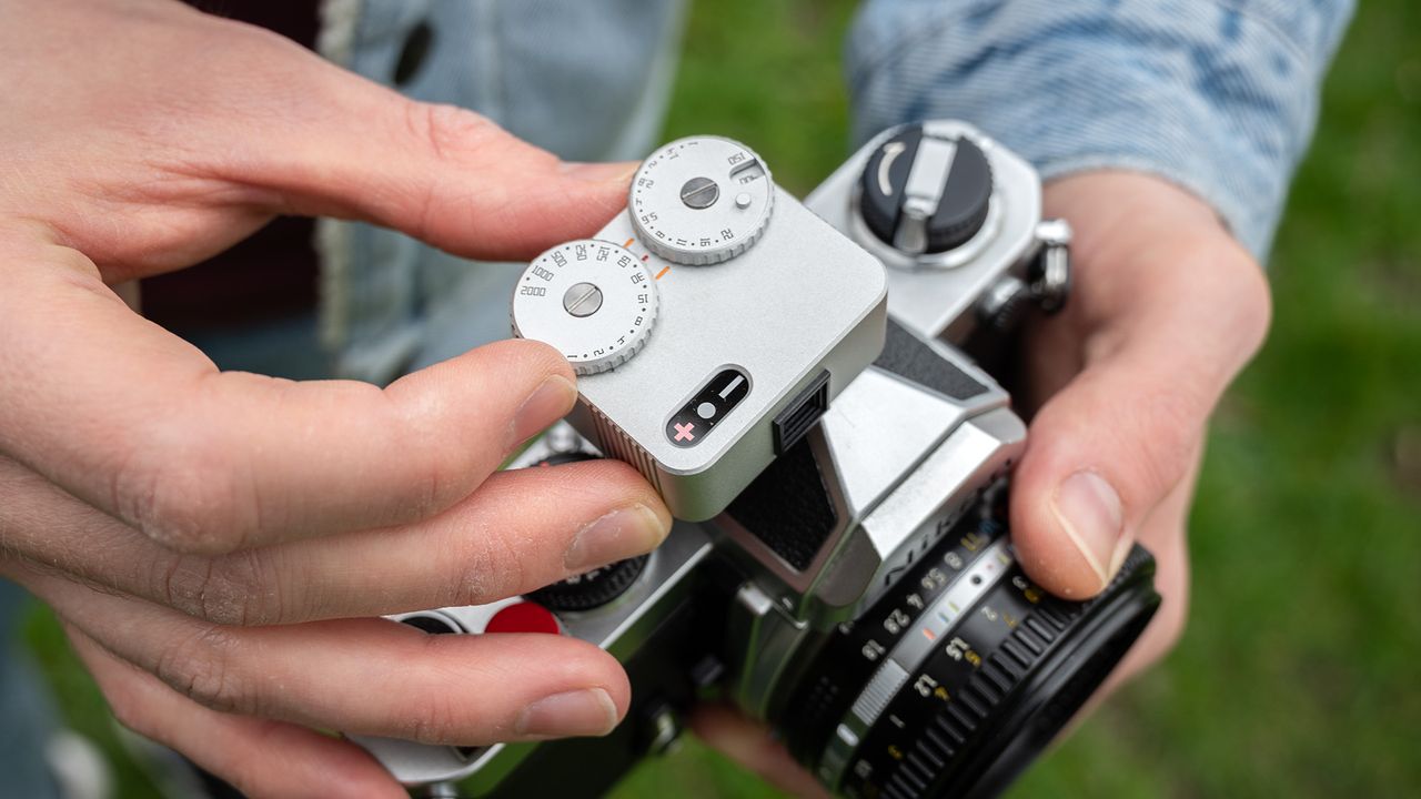 Close-up of TTArtisan Light Meter II on a Nikon FM being held out in the field
