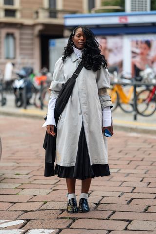 woman wearing coat, long skirt, loafers, and socks