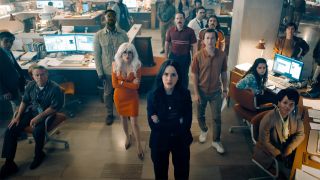 Cat grant, Lois Lane, Steve Lombard, and Jimmy Olsen looking an off-camera screen in The Daily Planet's newsroom in Superman