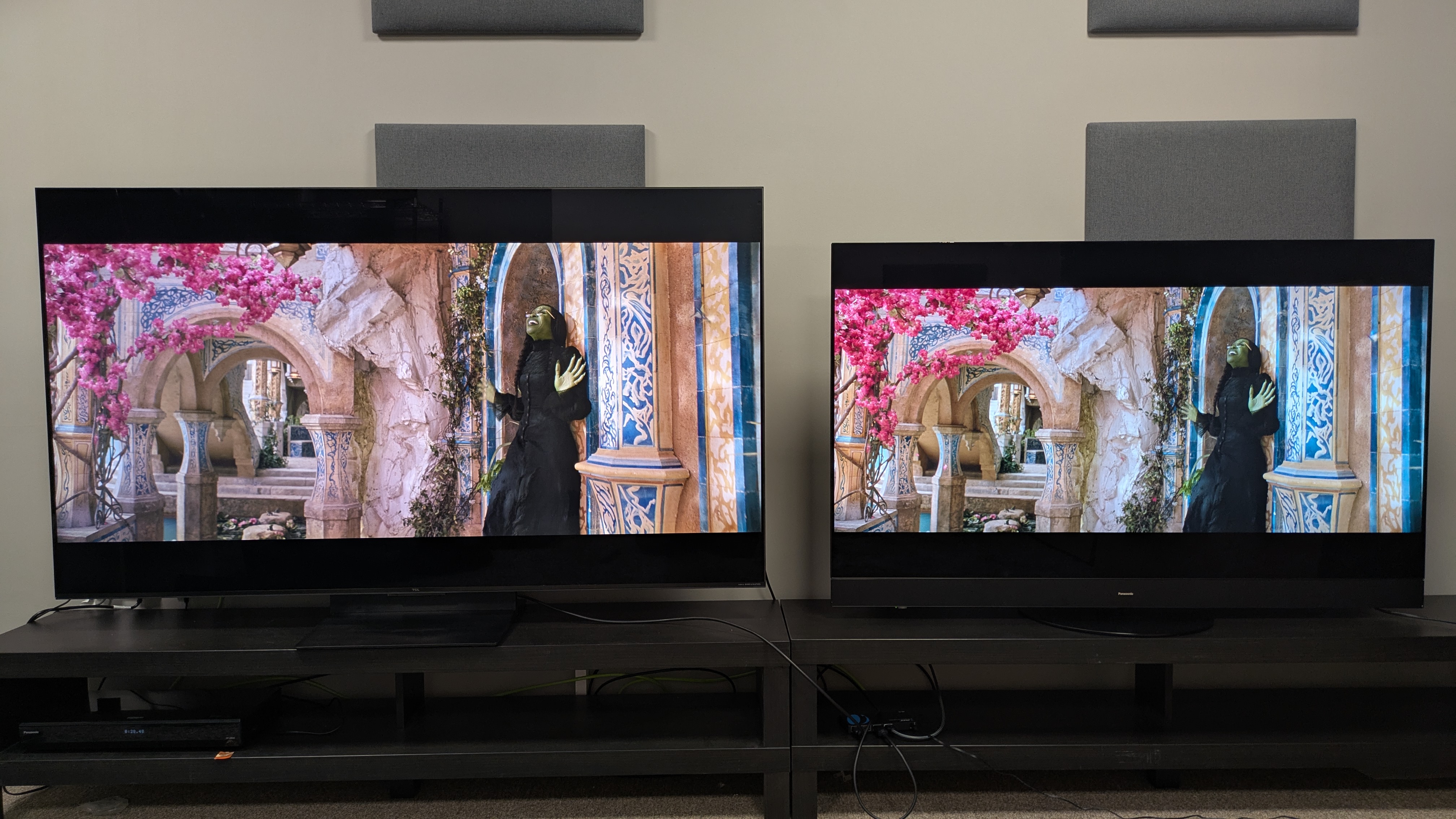 TCL C7K mini-LED left and Panasonic MZ1500 OLED right displaying Elphaba on a ledge from Wicked on screen