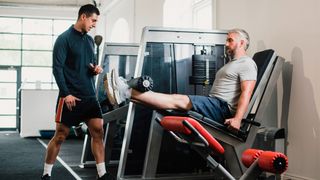 Man performs leg extension on weights machine