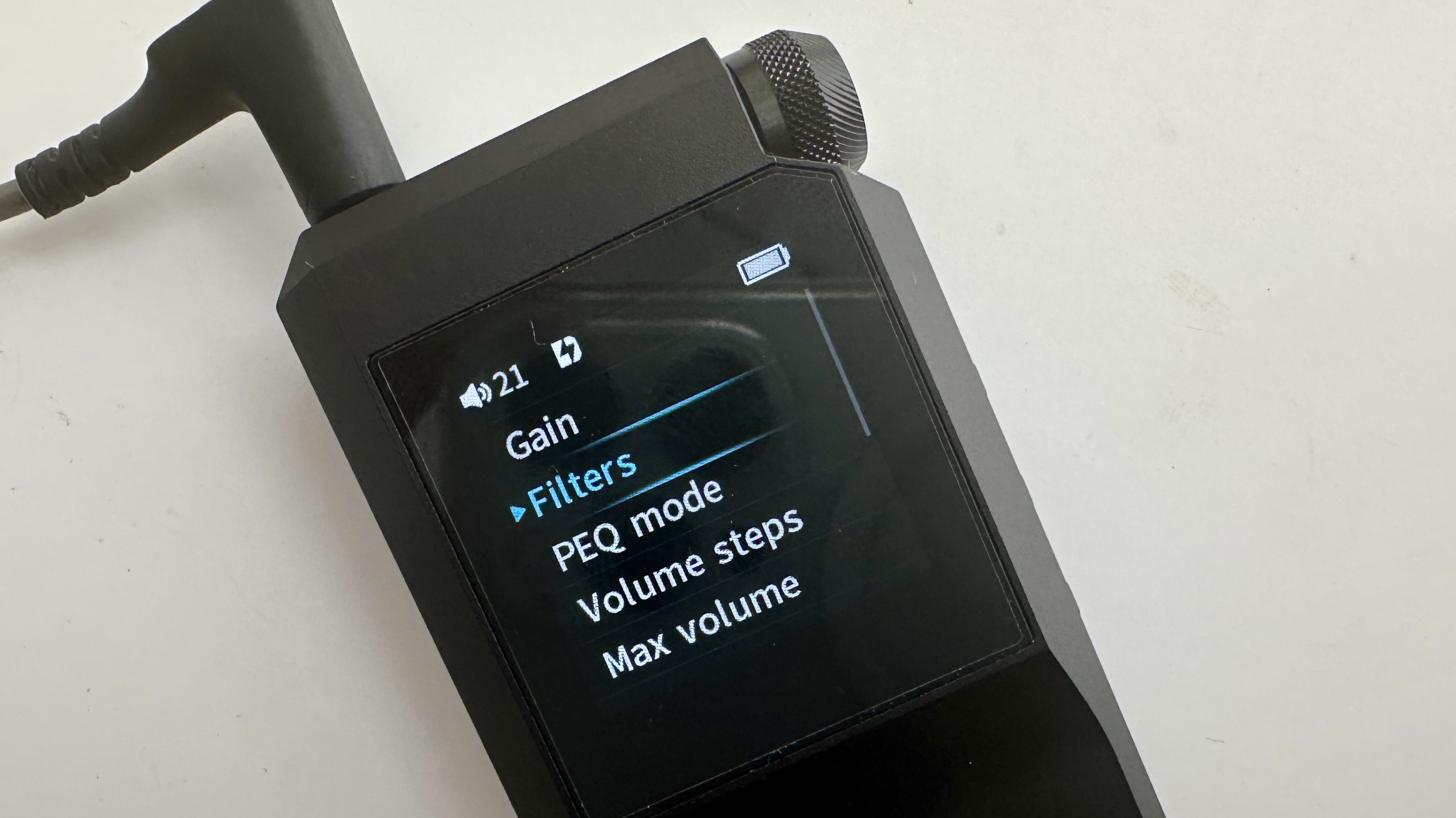 FiiO's BTR17 DAC/amp in black, on a gray table, showing PCM resolution in yellow font