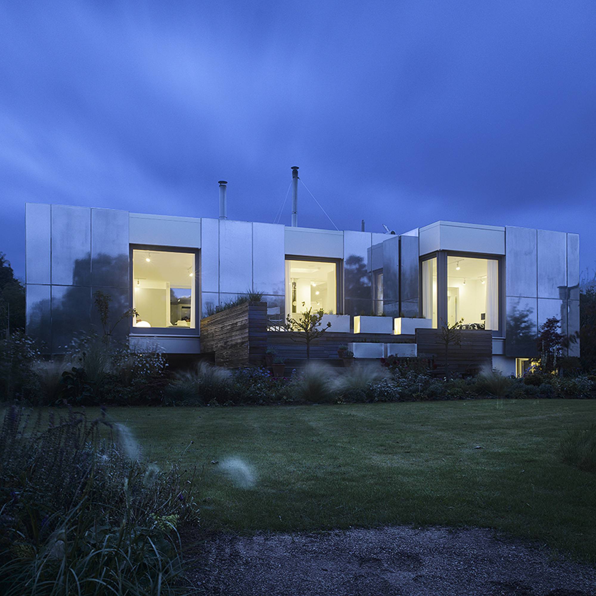 alumunium cladding on single storey house with landscaped garden at dusk