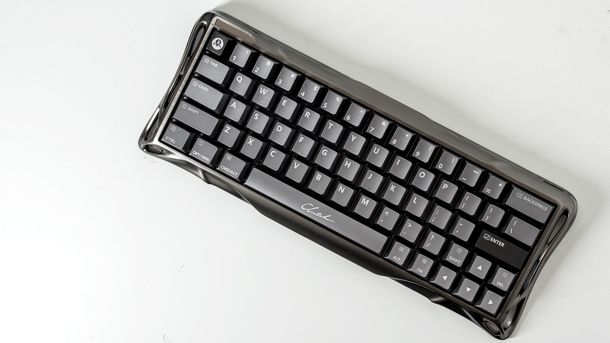 A Gravastar Mercury V60 Pro gaming keyboard with a shiny aluminium shell on a white desk.