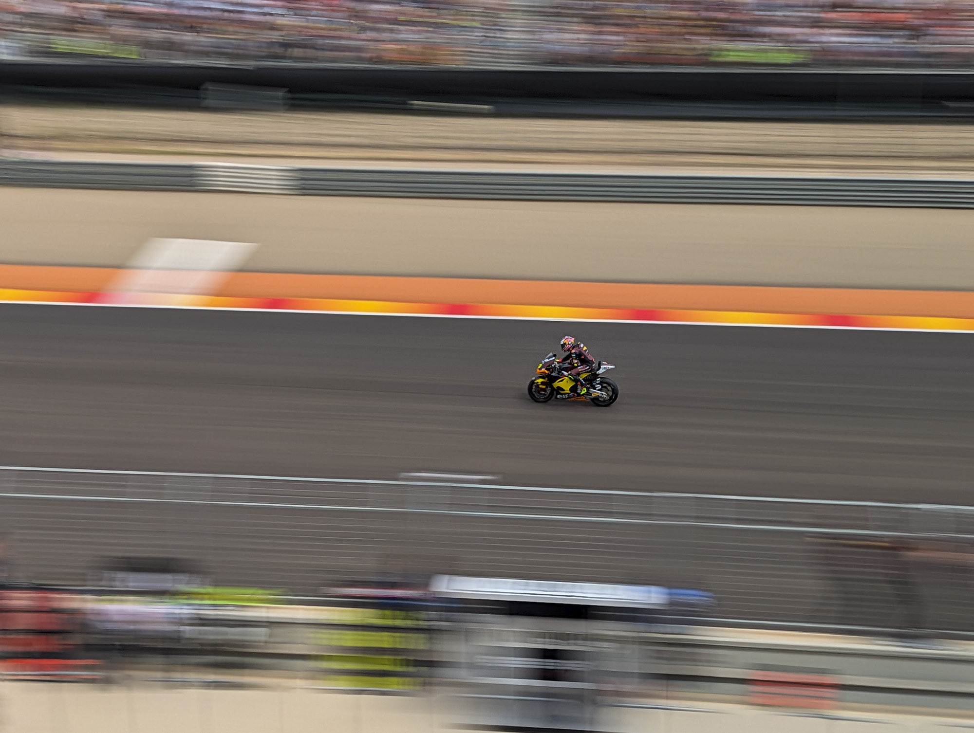 MotoGP rider on racetrack with action panning motion blur