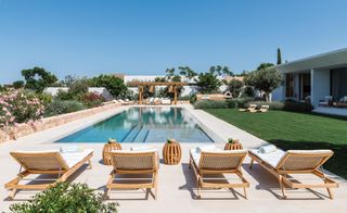 Swimming pool and gardens with lounge chairs at Sabina Estates Villa