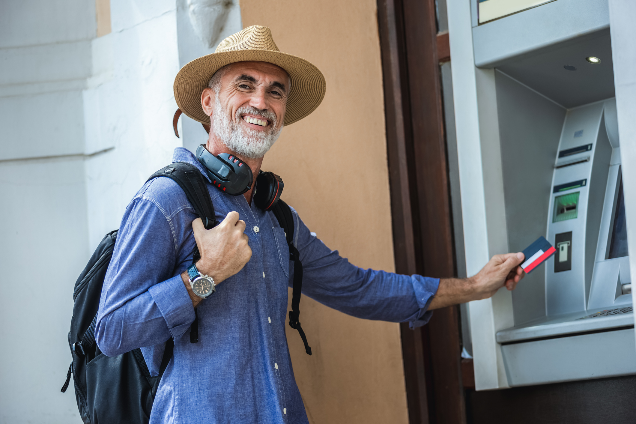 An older man withdraws his pension from an ATM
