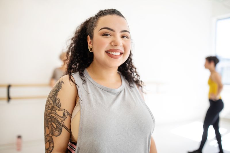 A woman smiling in a dance studio