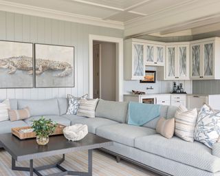 living room with light blue walls, large sectional and coastal decor