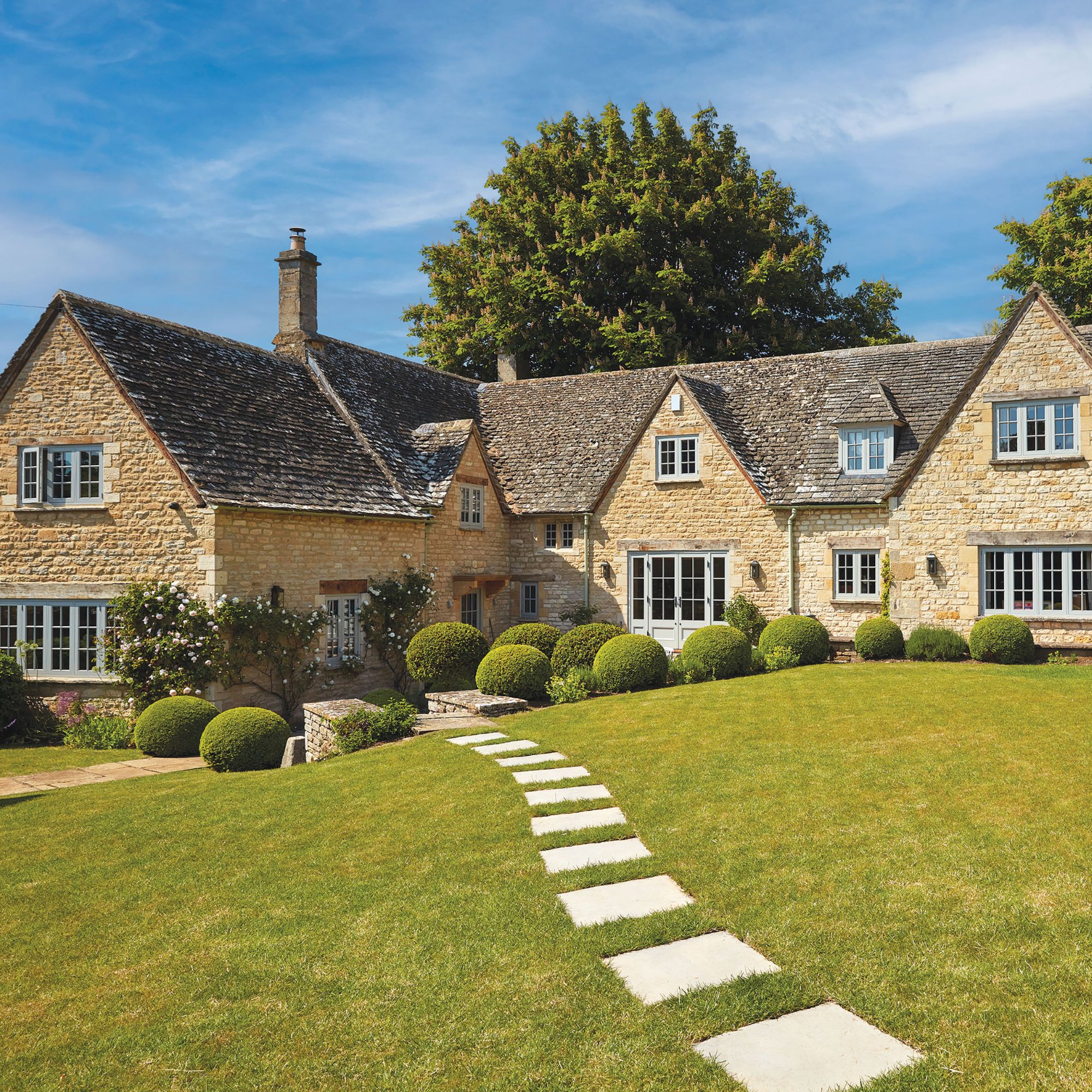 Horner home exterior - front grass with paving stones, bricked house with light blue windows and doors and lots of shrubbery
