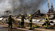 Emergency responders in front of a destroyed building in Ukraine