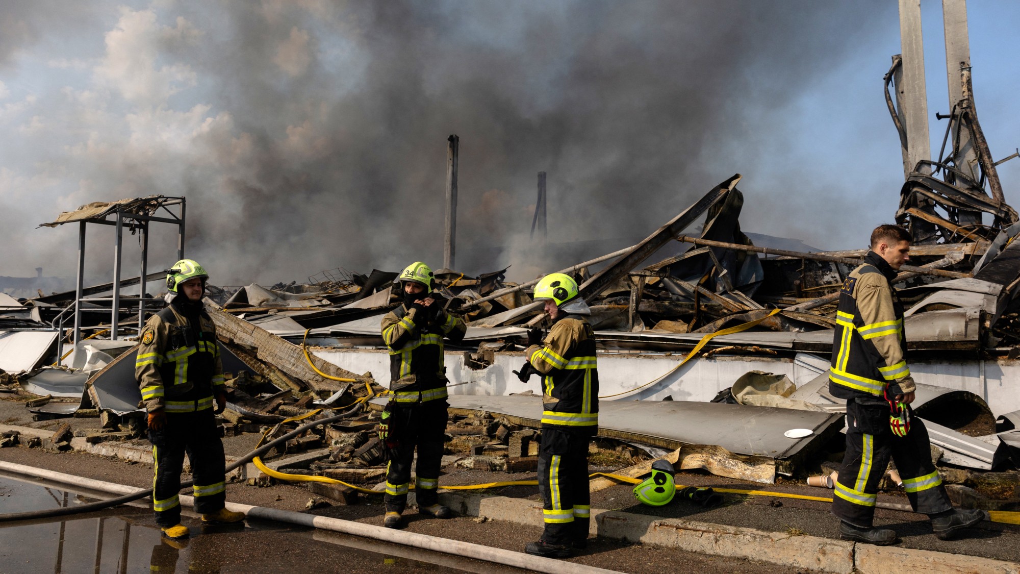 Emergency responders in front of a destroyed building in Ukraine
