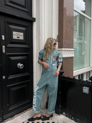 Eliza Huber wearing a Levi's x McLaren denim racing suit with black heels in London.