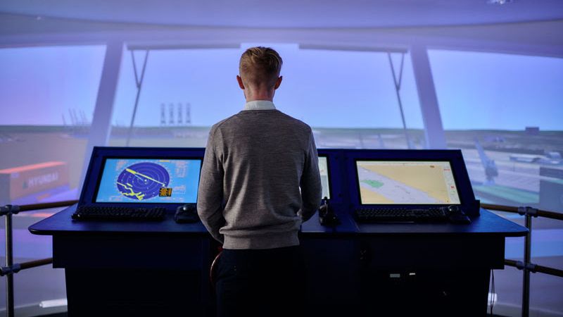 A person looks out aship simulation center with imagery on displays from ST Engineering Antycip.