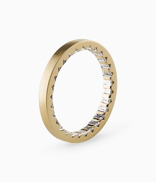 Le Gramme’s Ring is a circular gold ring with inner circle diamonds.