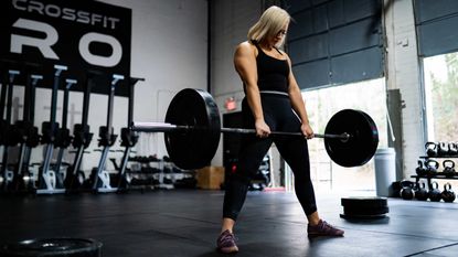 best barbell: pictured here, a female athlete using a barbell doing deadlifts