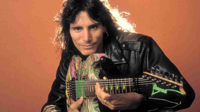 Steve Vai posing for a photograph while holding a guitar in 1990