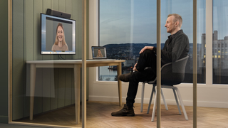 A man speaking with a woman in a huddle room using Neat videoconferencing solutions.