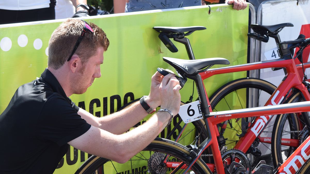A BMC Racing mechanic fixes the Velon data box to Paddy Bevin's bike