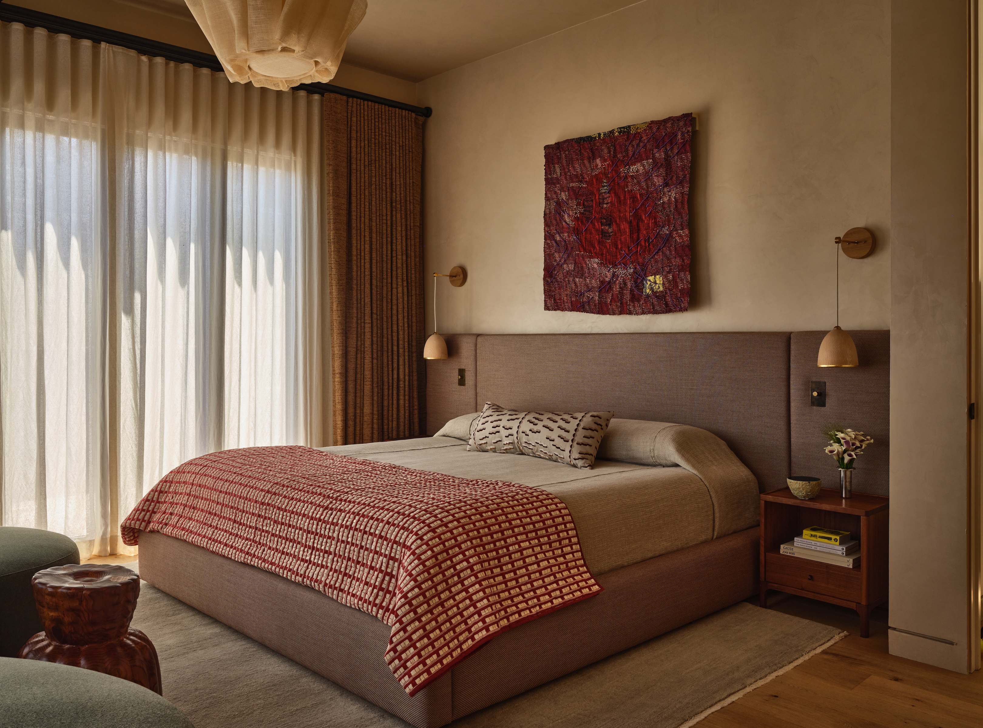 A contemporary bedroom with a symmetrical layout featuring matching nightstands, bedside lighting, and accent chairs