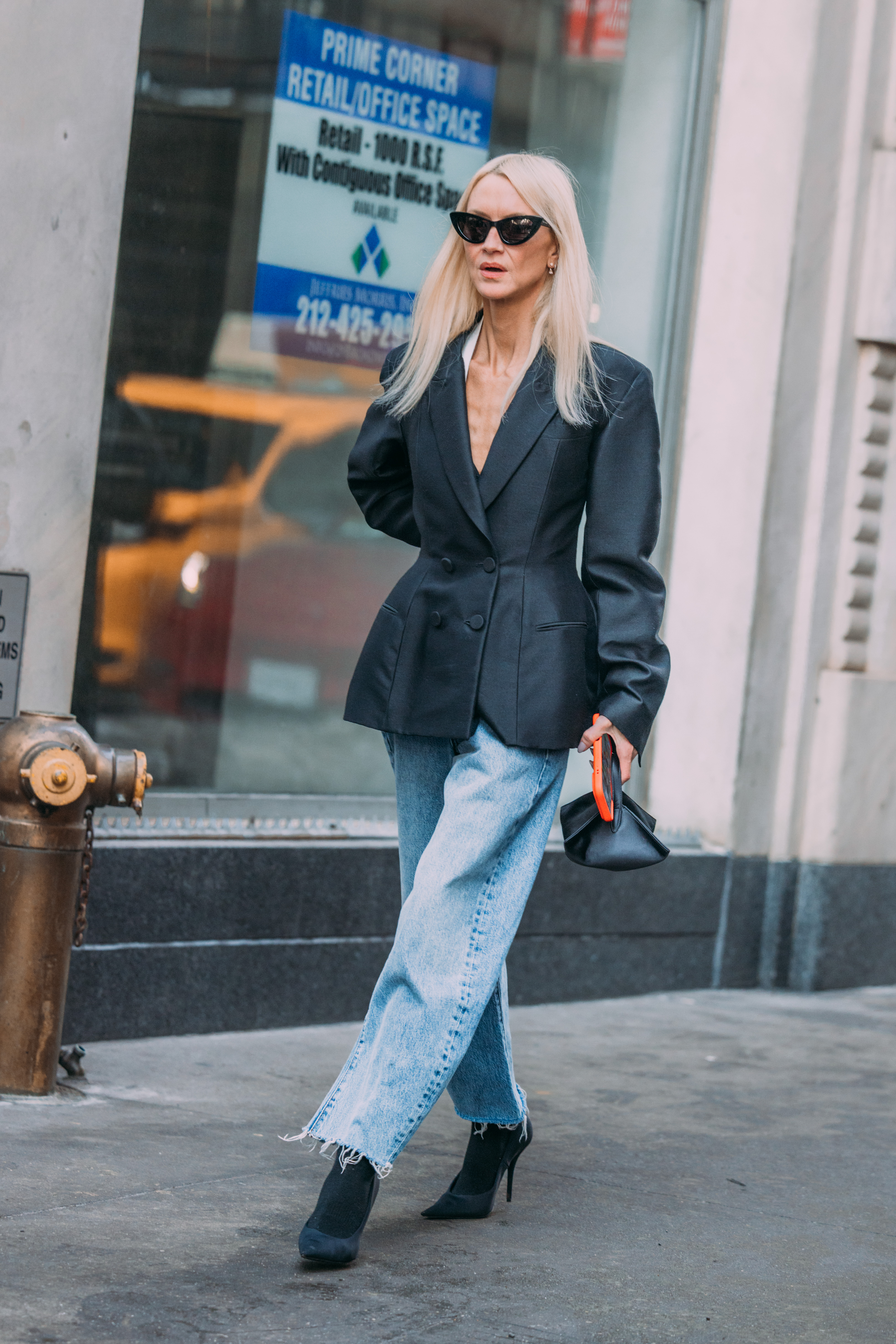 A woman wears frayed jeans with a jacket.