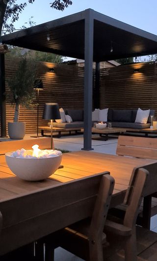 A backyard with a firepit bowl on a wooden table