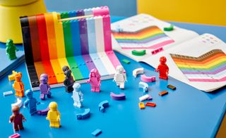 Brightly coloured Lego figures against a half built rainbow