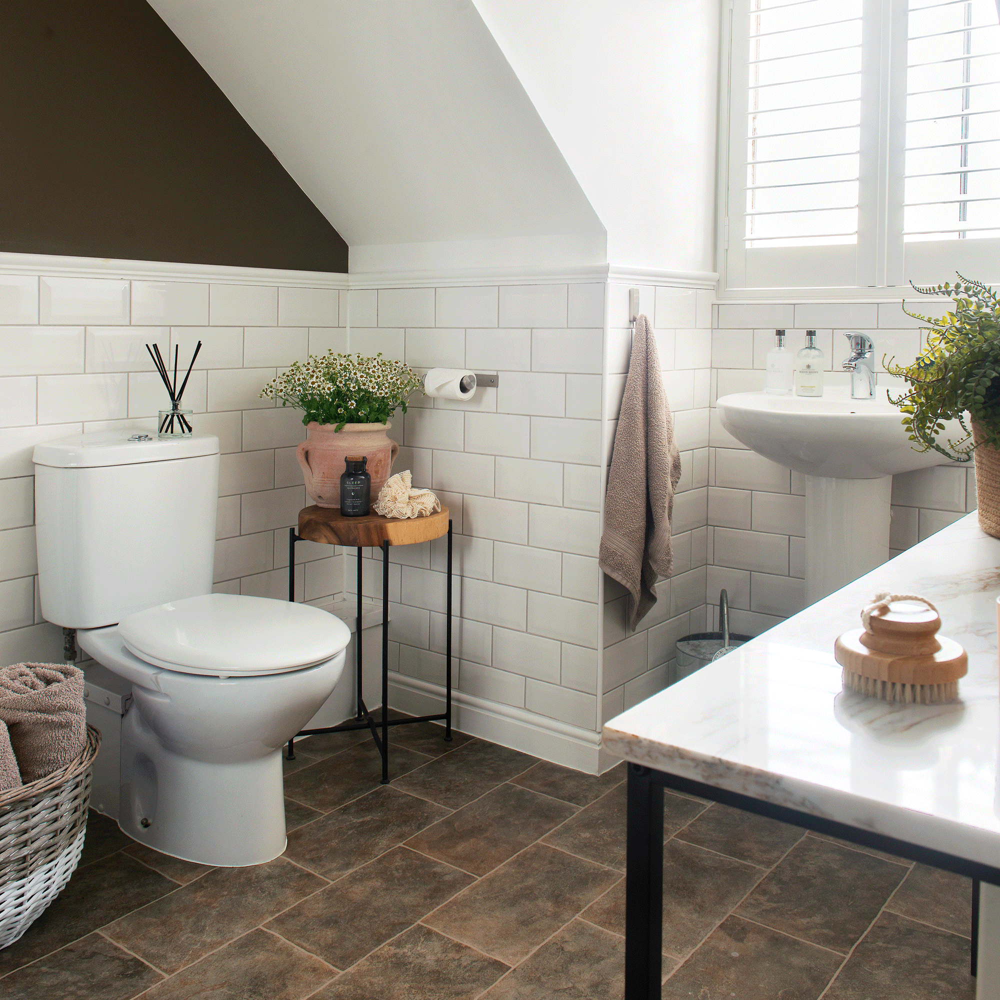 a neutral bathroom with metro tiled walls and a basin, look and slate style tiled flooring