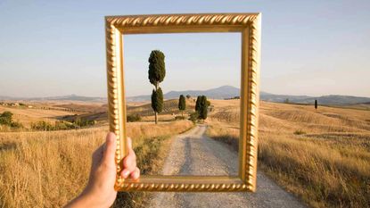 An empty picture frame outlines a peaceful scene of a country road.