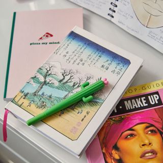 Journal and books with pen on desk