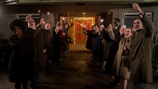 All of Nancy and Roger's friends stand in a line with sparklers in the dark, welcoming them to their wedding party