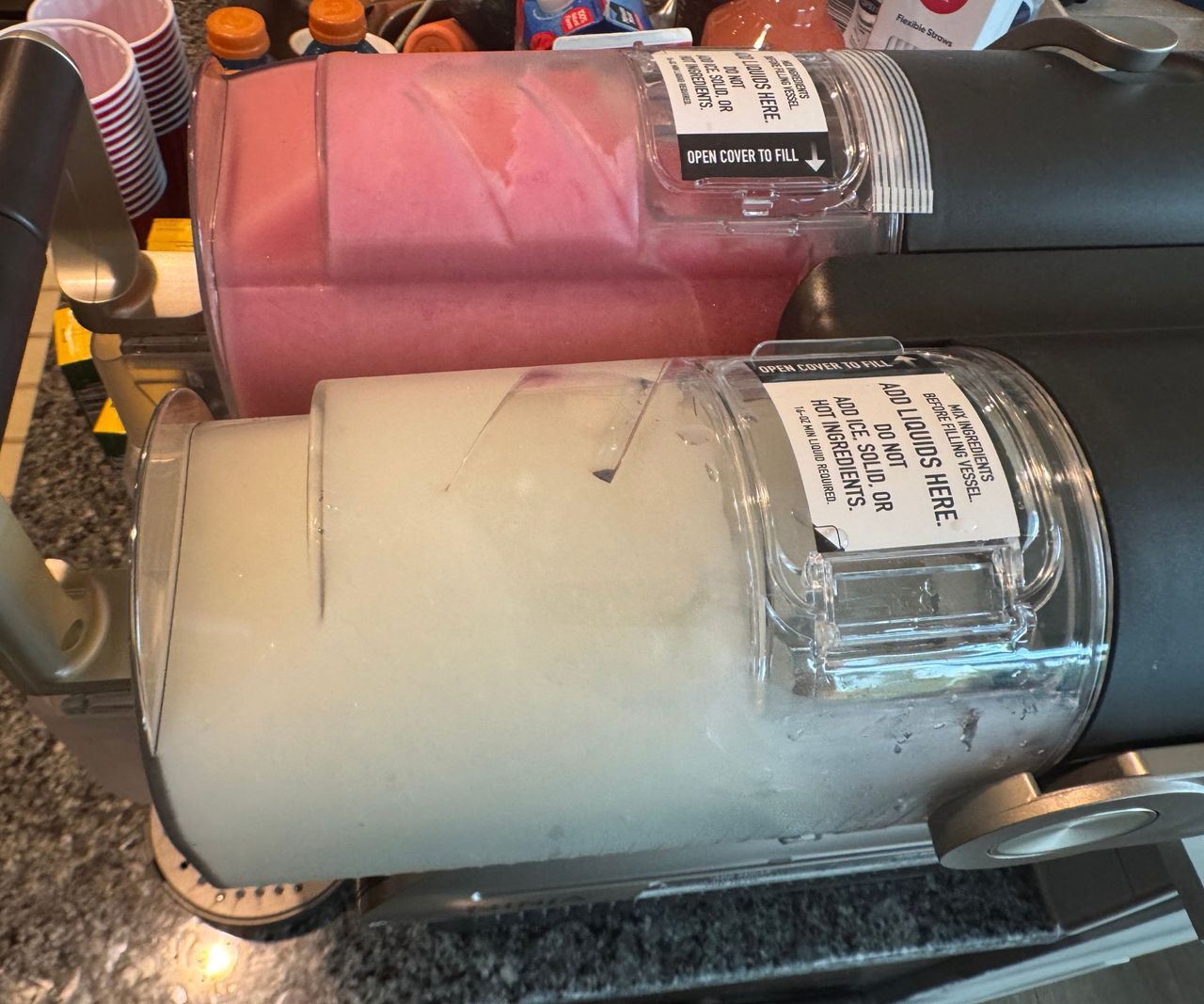 A top down view of a ninja slushi twist machine with pink slush in one side and white in the other.