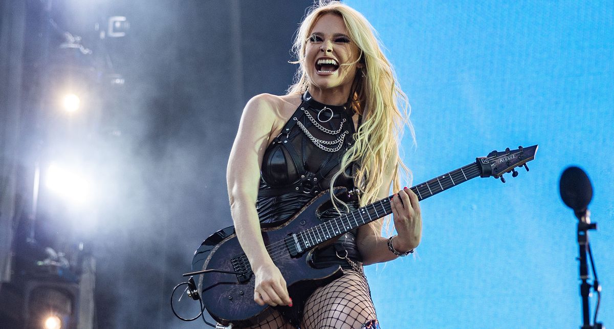 Sophie Lloyd onstage with her signature Kiesel in Norway, blue sky behind her