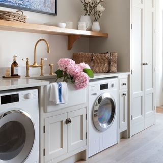 washing machine in utility area with sink and pink hydrangeas