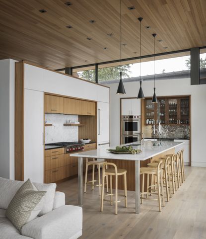 a modern, naturally lit kitchen with wood detailing